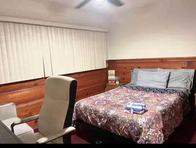 a bedroom with a bed and a chair next to a bed at Room in Monterey Park CA in Monterey Park