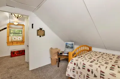 a bedroom with a bed and a desk with a computer at Moonridge R n R- Cozy Single Level Central Chalet Home in Big Bear Lake
