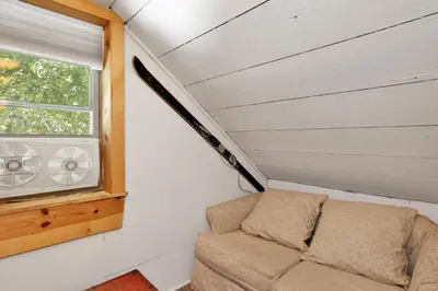 a couch in a tiny house with a window at Moonridge R n R- Cozy Single Level Central Chalet Home in Big Bear Lake