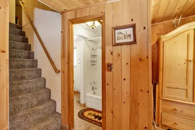 a stairway leading to a bathroom with a tub at Moonridge R n R- Cozy Single Level Central Chalet Home in Big Bear Lake