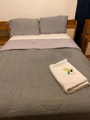 a bed with a blanket and a towel on it at House Rooms & RV Rooms Near LAX in Los Angeles