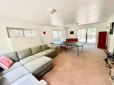 a living room with a couch and a ping pong table at Family Friendly A Frame, Pets stay Free! in Lake Arrowhead