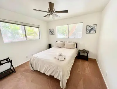a white bedroom with a bed with a ceiling fan at Family Friendly A Frame, Pets stay Free! in Lake Arrowhead