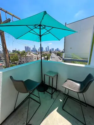 a table and two chairs and an umbrella on a balcony at Downtown Los Angeles Skyline balcony view Modern Penthouse in Los Angeles