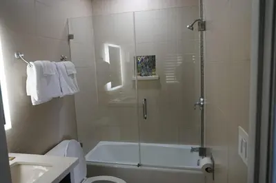 a bathroom with a shower with a tub and a toilet at Avenue Motel in Gardena