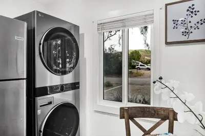 a kitchen with two washing machines next to a window at Retro Cottage, Hot Tub, Putting Green, walk to all in Thousand Oaks