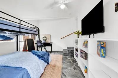 a bedroom with a bed and a flat screen tv at Retro Cottage, Hot Tub, Putting Green, walk to all in Thousand Oaks