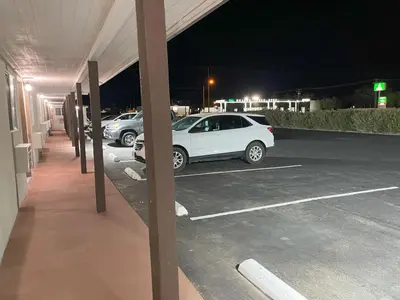 a white car parked in a parking lot at night at Palm Inn in Mojave