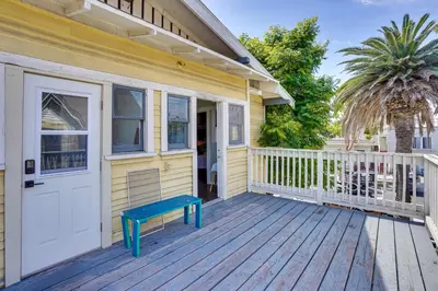 a yellow house with a blue bench on a deck at 1 Mi to Dtwn! Bright Long Beach Apartment in Long Beach