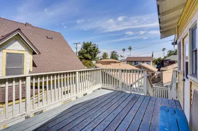 a deck with a white fence and a house at 1 Mi to Dtwn! Bright Long Beach Apartment in Long Beach