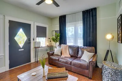 a living room with a brown leather couch and a table at 1 Mi to Dtwn! Bright Long Beach Apartment in Long Beach