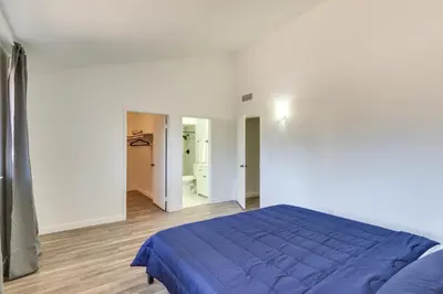 a bedroom with a blue bed and a bathroom at Quiet Ridgecrest Vacation Rental with Private Yard! in Ridgecrest