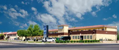 a building with a car parked in front of it at America Inn & Suites in Ridgecrest