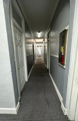 an empty hallway with a long corridor with a door at Unity Hotel - No Parking & Rooms Are Upstairs in Long Beach