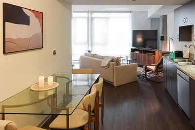 a living room with a glass table and a kitchen at Luxurious Hollywood Dream in Los Angeles