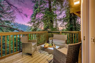 a porch with chairs and a table on a deck at Tree-Lined Lake Arrowhead Cabin about 1 Mi to Village! in Lake Arrowhead