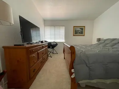 a bedroom with a bed and a dresser with a television at Ploy in Monterey Park