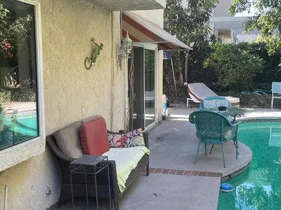 a patio with chairs next to a swimming pool at Ploy in Monterey Park