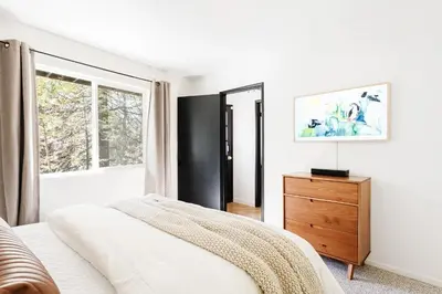 a bedroom with a bed and a dresser and a window at Modern Designer Cabin, Newly Renovated, EV Charger, Arcade, Kids Bunkbed, Minutes to Lake Arrowhead and Lake Gregory in Twin Peaks