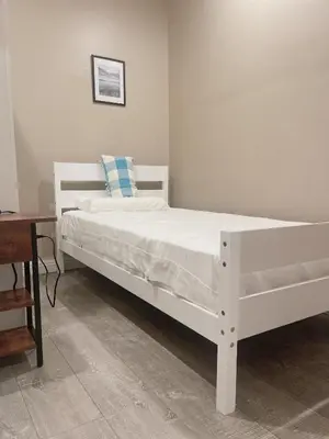 a white bed sitting in a room with a desk at cozy & Quiet Tow Bed & one bath in Rosemead