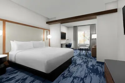 a hotel room with a white bed and a desk at Fairfield Inn & Suites Riverside Corona/Norco in Norco