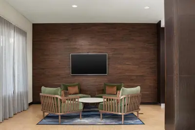 a living room with a tv on a brick wall at Fairfield Inn & Suites Riverside Corona/Norco in Norco