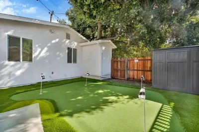 a backyard with a putting green and a house at Modern Cottage, Hot Tub, Bistro Patio, Putting Green, Walk to All! in Thousand Oaks
