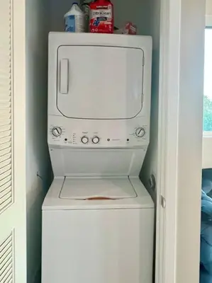 a white microwave sitting on top of a washer at Luxe Corner Penthouse 1BR Condo on Sunset in Los Angeles