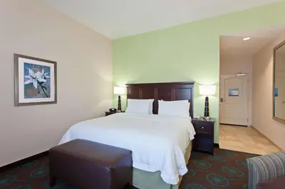 a hotel room with a large bed and a chair at Hampton Inn Los Angeles Int'l Airport/Hawthorne in Los Angeles