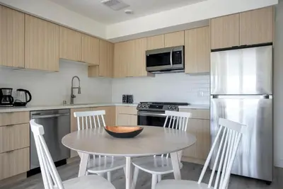 a kitchen with a table and chairs and a refrigerator at West LA 1br w rooftop gym nr restaurants LAX-1103 in Los Angeles