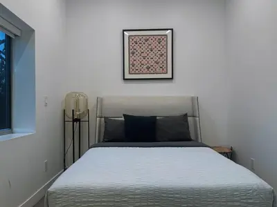 a bed in a bedroom with a picture on the wall at Stunning View Hollywood Hills Guest House in Los Angeles