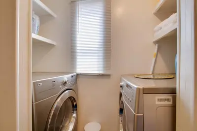 a laundry room with a washing machine and a window at Rosamond Vacation Rental with Grill, Near Vineyards! in Rosamond