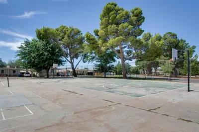 an empty basketball court with trees and a basketball hoop at Rosamond Vacation Rental with Grill, Near Vineyards! in Rosamond