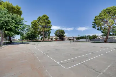 an empty tennis court with trees in the background at Rosamond Vacation Rental with Grill, Near Vineyards! in Rosamond