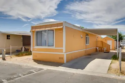 a small yellow building with a large window at Rosamond Vacation Rental with Grill, Near Vineyards! in Rosamond