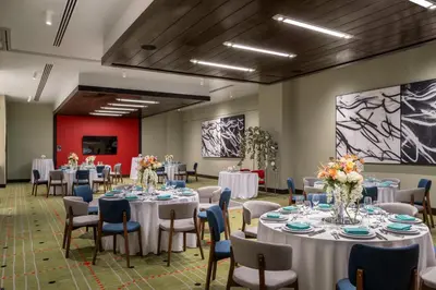 a conference room with tables and chairs and flowers at Hilton Buena Park Anaheim in Buena Park