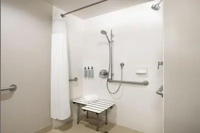 a bathroom with a shower with a bench in it at Courtyard by Marriott Los Angeles L.A. LIVE in Los Angeles