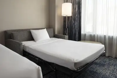 a hotel room with a bed and a couch at Courtyard by Marriott Los Angeles L.A. LIVE in Los Angeles