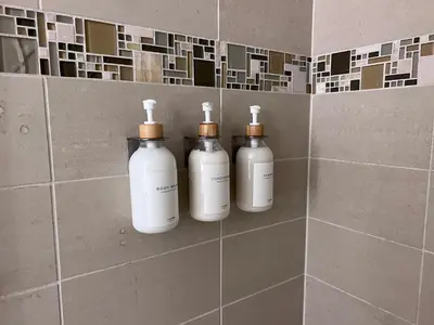 a group of three bottles on a wall in a bathroom at Arion- Cozy Santa Monica getaway steps to the beach Free Parking in Los Angeles