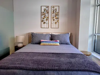 a bedroom with a large bed with blue pillows at Arion- Cozy Santa Monica getaway steps to the beach Free Parking in Los Angeles