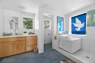 a bathroom with a bird painting on the wall at Amazing Grace - Zen mountain retreat with lake views in Fawnskin