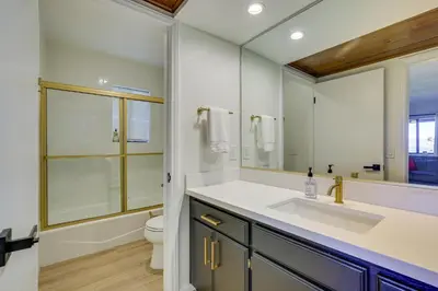 a bathroom with a sink and a toilet and a mirror at 3 Decks, Game Room and Views Lake Arrowhead Home! in Lake Arrowhead
