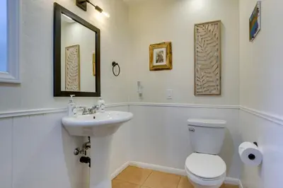 a bathroom with a sink and a toilet and a mirror at 3 Decks, Game Room and Views Lake Arrowhead Home! in Lake Arrowhead