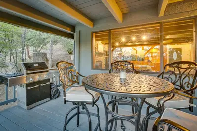 a patio with a table and chairs on a porch at 3 Decks, Game Room and Views Lake Arrowhead Home! in Lake Arrowhead