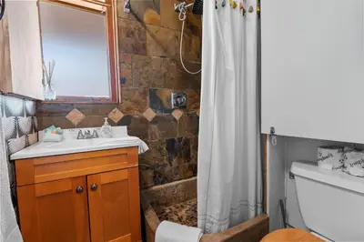 a bathroom with a sink and a shower curtain at Clerestory Cottage - The perfect cozy getaway with a hot tub in Big Bear Lake