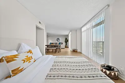 a bedroom with a bed and a dining room at The Lilas-Ocean view Stay high floor Pool Parking in Los Angeles
