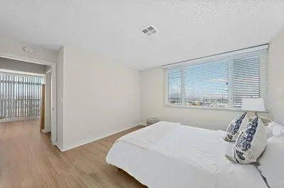 a white bedroom with a large bed and a window at The Lilas-Ocean view Stay high floor Pool Parking in Los Angeles