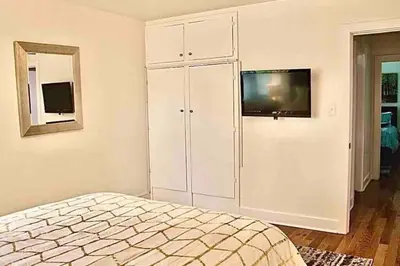 a bedroom with a bed and a tv on a wall at Pool Table A C Grill Out Netflix Bikes Yard in Fullerton