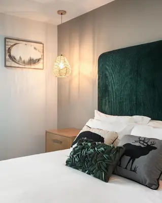 a bedroom with a bed with a green headboard at California Inn in Anaheim