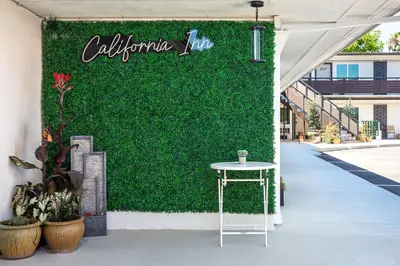 a green wall with a table on a sidewalk at California Inn in Anaheim